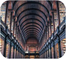 A large library with extensive rows of bookshelves and arched ceilings.
