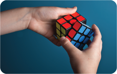 Two hands solving a Rubik's cube on a blue background.